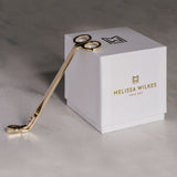 Packaging for the candles is a pristine white texture soft paper hand wrapped around hard card to create the most beautiful gift box. The memorable MW icon is on the top of the box with the full Melissa Wilkes England branding on the side. Both are gold foiled which make this box look and feel prestige and luxurious. In line with our sustainable principles this gift box is recyclable but even better reuse-able. Nestled next to the box is our gold wick trimmers.